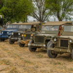 Several different Jeeps from different eras of military service line up at the 2025 Wings, Tracks, and Wheels event at Chino Airport.